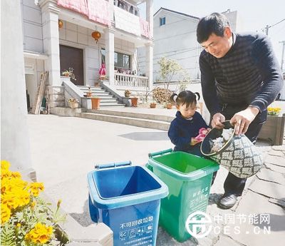 安吉县昌硕街道双一村的村民把生活垃圾倒进自家门口的垃圾桶。